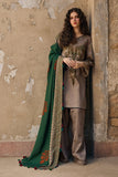 Woman in traditional outfit with a green dupatta against a textured wall.