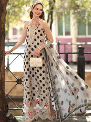 Woman in a polka dot dress with floral patterns standing outdoors.