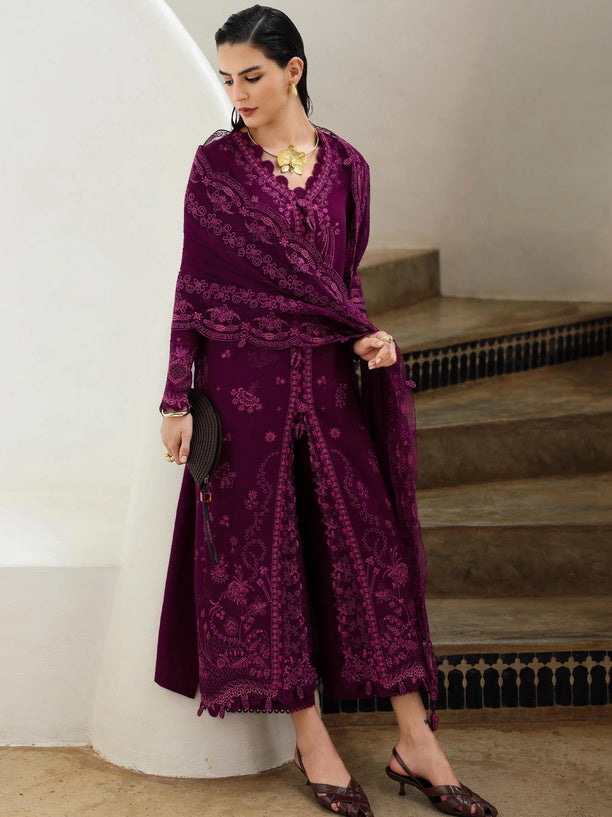 Woman in a purple outfit standing in front of a white wall with steps.