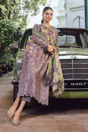 Woman in a patterned outfit standing next to a vintage car