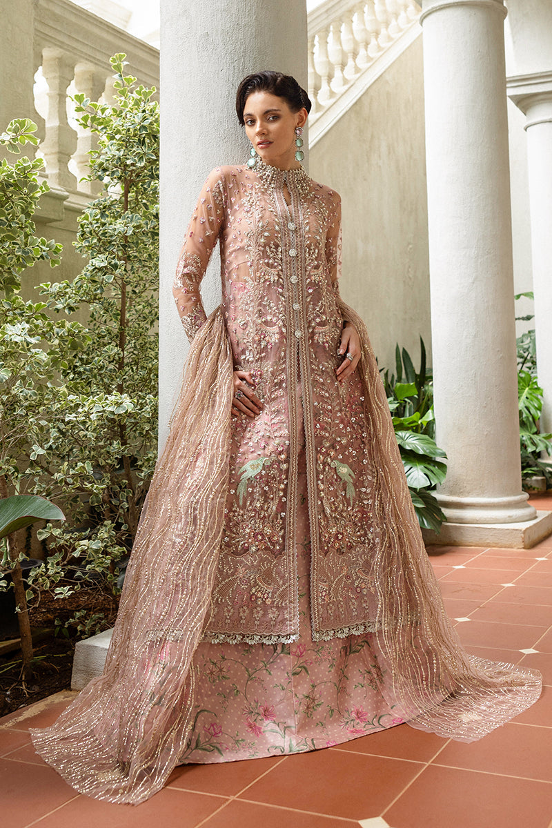 Woman in a traditional embroidered outfit standing in an elegant indoor setting with columns and plants.