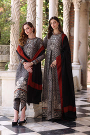 Two women in traditional outfits standing in a decorative setting with columns and greenery.
