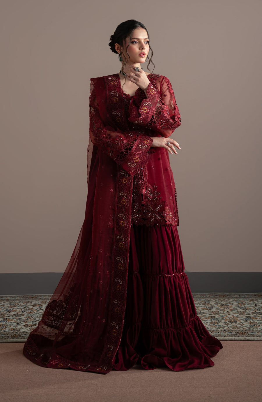 Woman wearing a burgundy embroidered traditional outfit against a neutral background | Pret collection Elvin By Fabiha Fatima